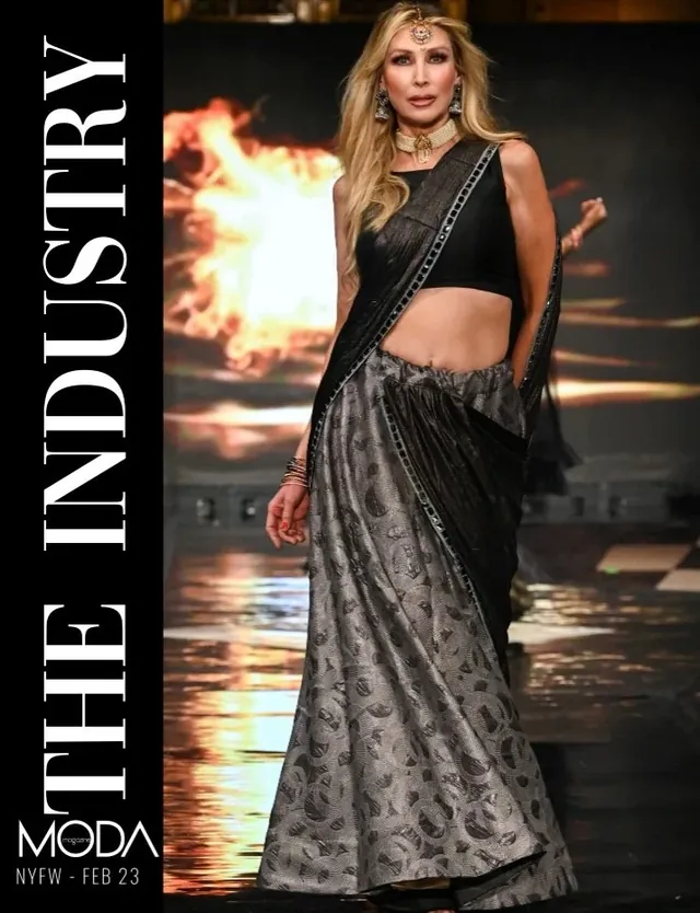 Cover of The Industry, MODA magazine, NYFW February 2023: a model on the runway before a fiery LED backdrop.